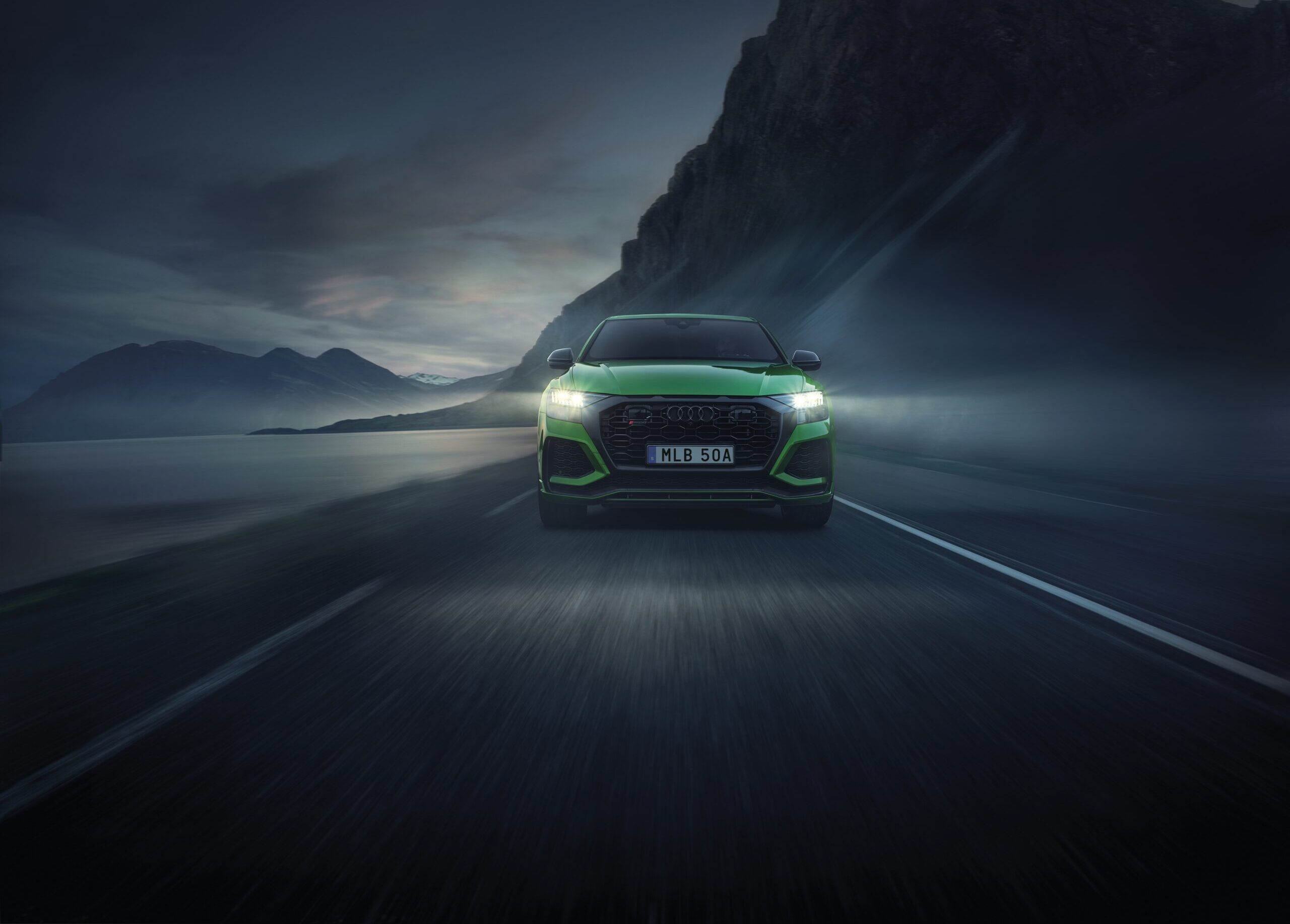 Grön Audi som kör på väg i dimman