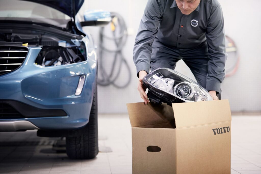 En man packar upp Volvo Originaldelar ur en kartong i en verkstad